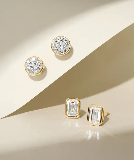 Round and emerald-cut diamond stud earrings in soft natural light